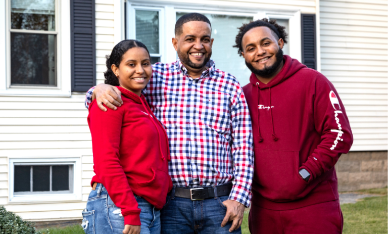 Family poses outside of newly purchased home